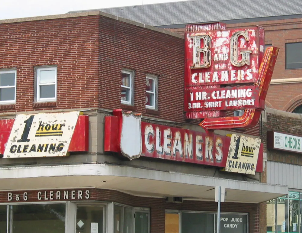 Photo of a vintage metal sign on a building